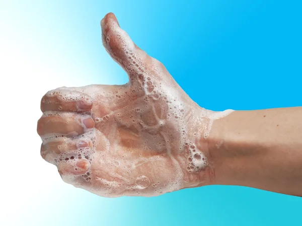 Ręce mydłem damska Dokonywanie kciuk w, na białym tle na niebieskim tle — Zdjęcie stockowe