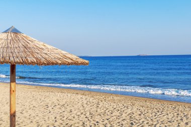 Sahilde deniz kenarına Reed şemsiye