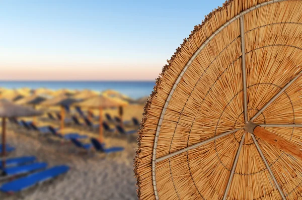 Sombrillas de caña de playa en la playa borrosa — Foto de Stock