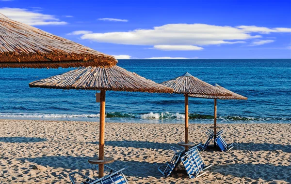 Solarium, halm paraply på vackra stranden bakgrund — Stockfoto