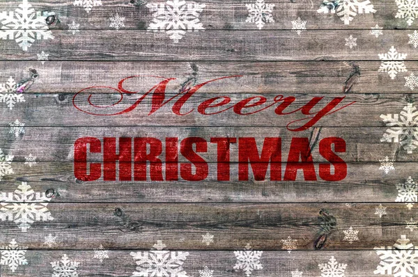 Feliz Natal vermelho escrito em tábua de madeira com snoflake — Fotografia de Stock