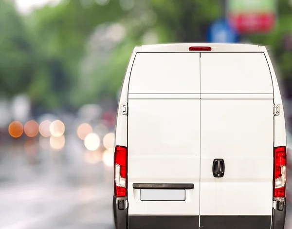 Weißer Lieferwagen fährt schnell auf Stadt verschwommen Bokeh Straße — Stockfoto