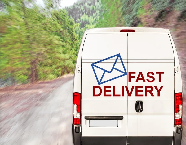 White FAST DELIVERY Van ajaa nopeasti metsätiellä — kuvapankkivalokuva