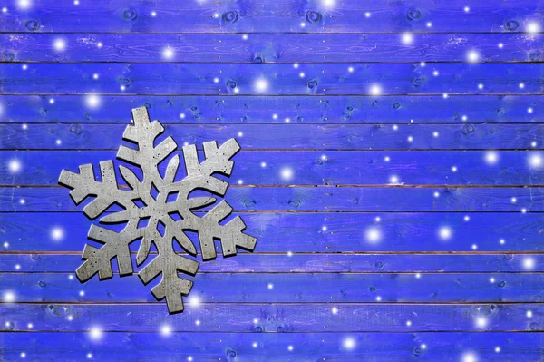 Νιφάδα χιονιού σιδήρου στο ξεπερασμένο μπλε ξύλινη σανίδα — Φωτογραφία Αρχείου
