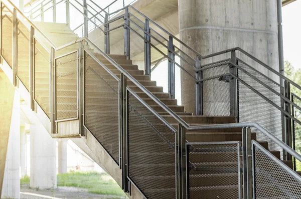 Σκάλες από μπετό είναι μεταλλικά κιγκλιδώματα με πορτοκαλί φως του ήλιου — Φωτογραφία Αρχείου
