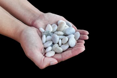 Küçük taşlar siyah arka plan üzerine izole elinde tutan eller kadın