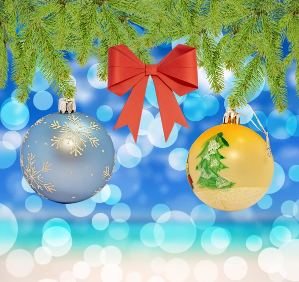 Bola azul y amarilla decorativa de Navidad con lazo rojo sobre fondo bokeh —  Fotos de Stock