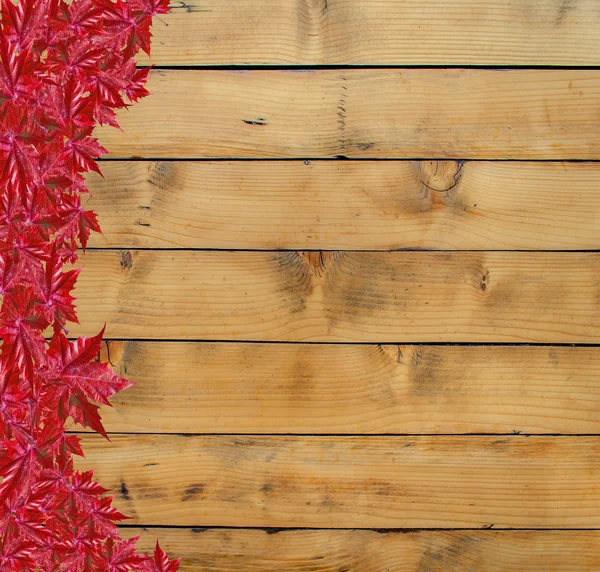 木の板と赤い葉の秋の背景 — ストック写真