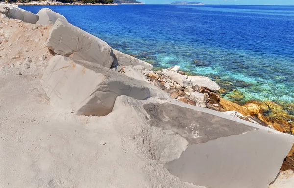 Grandes bloques blancos de mármol crudo y mar en Grecia —  Fotos de Stock
