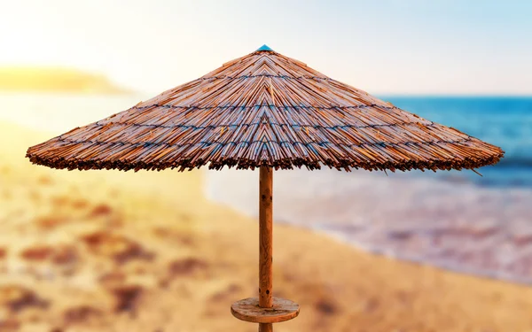 Sombrillas de caña playa con playa borrosa — Foto de Stock