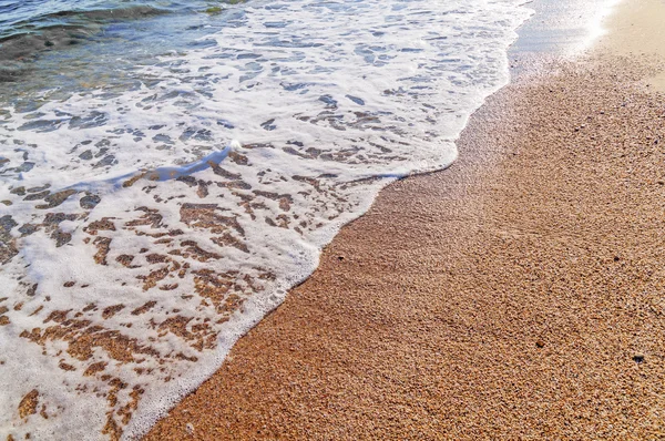 ギリシャのクローズ アップで波に砂のビーチ — ストック写真