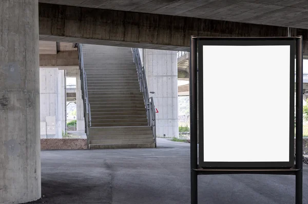 Cartelera en blanco sobre fondo de pared de hormigón debajo del puente con escaleras arriba — Foto de Stock