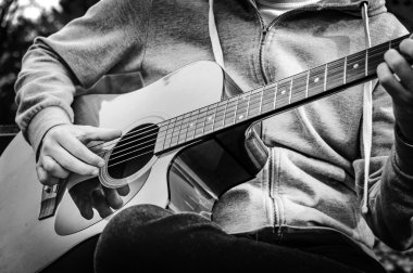 B&W - genç sonbahar parkta bankta akustik gitar çalmak adam