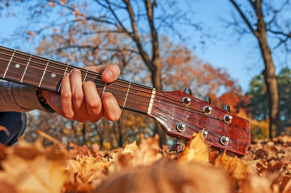 Człowiek posiadający gitary szyi blisko parku jesień — Zdjęcie stockowe