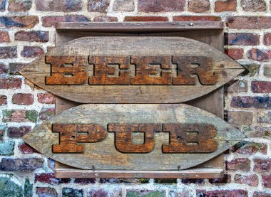 Bira Pub ahşap işareti renkli tuğla duvar arka plan üzerinde astı