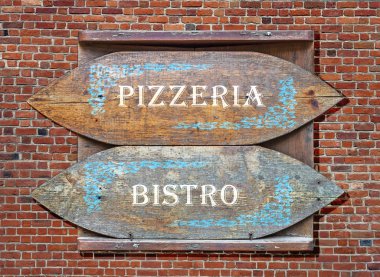 Ahşap işaretler - pizzeria ve tuğla duvar arka plan üzerinde asıldı Bistro'da için