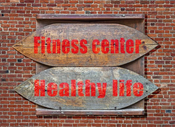 Fitness Center e Vida Saudável Sinal velho de madeira pendurado no fundo da parede de tijolo — Fotografia de Stock