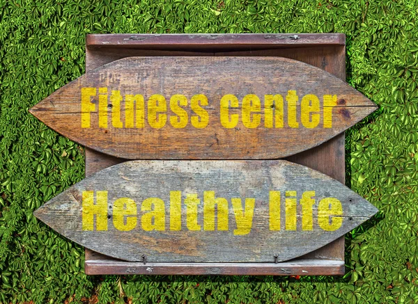 Fitness Center e Vida Saudável Sinal velho de madeira pendurado em fundo de sebe de hera trepadeira — Fotografia de Stock