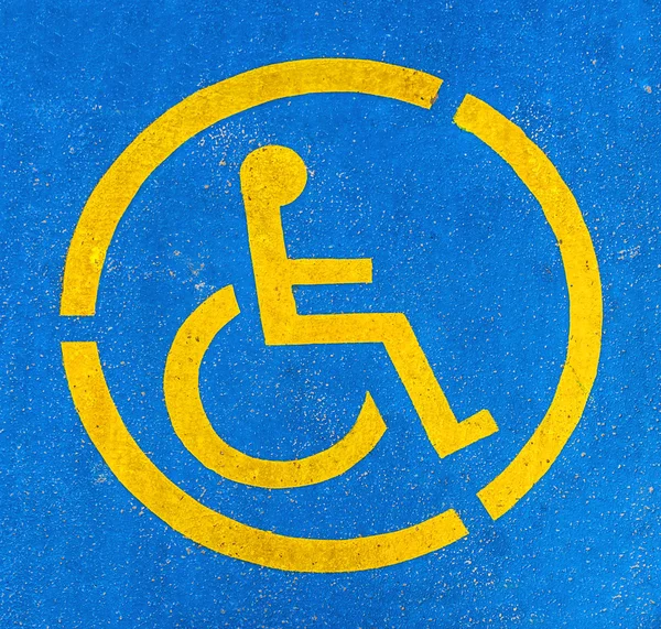 Panneau de stationnement pour handicapés bleu et jaune sur asphalte, personnes handicapées — Photo