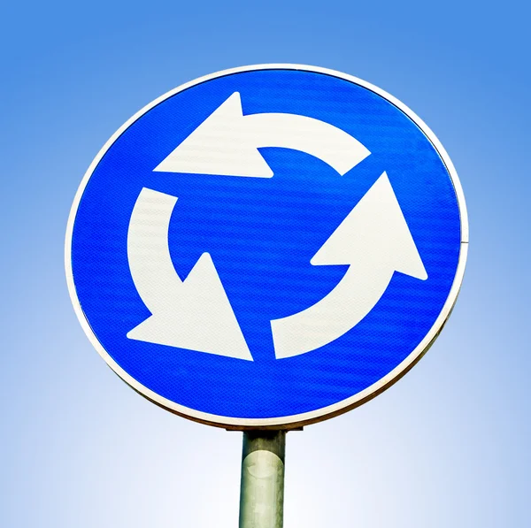 Rotunda azul sinal de trânsito rodoviário cruzado contra fundo azul — Fotografia de Stock
