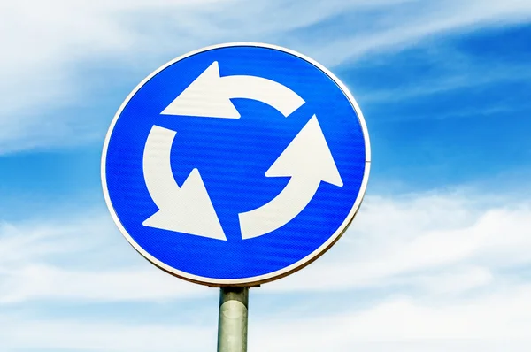Blue roundabout crossroad road traffic sign against blue sky — Stock Photo, Image