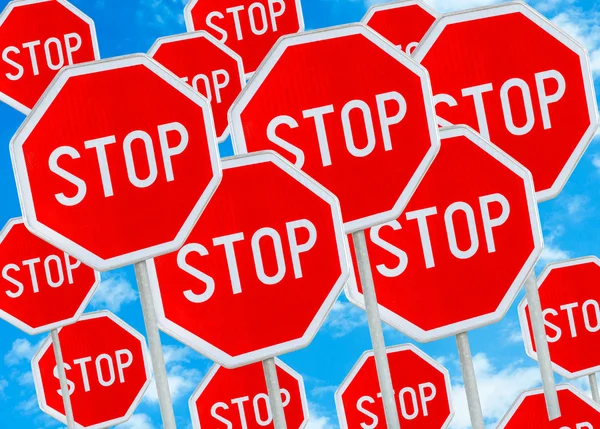 Segno di stop multiplo contro sfondo cielo blu — Foto Stock