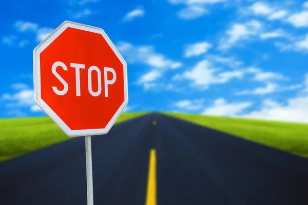 Red realistic stop road sign on blured road with sky — Stock Photo, Image