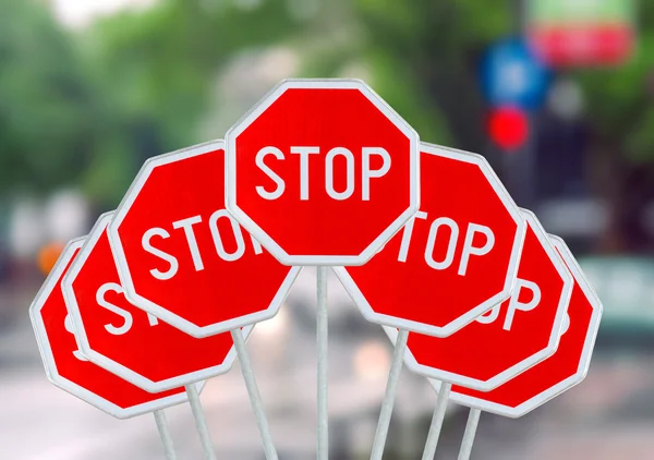 Several STOP sign on blurred city road — Stock Photo, Image