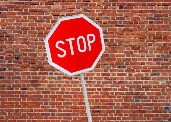 Stopbord op een bakstenen muur achtergrond — Stockfoto
