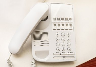 Otel odasında masa üzerinde telefon