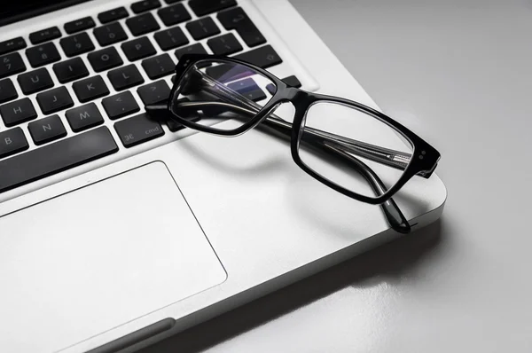 Óculos de empresário em computador portátil — Fotografia de Stock