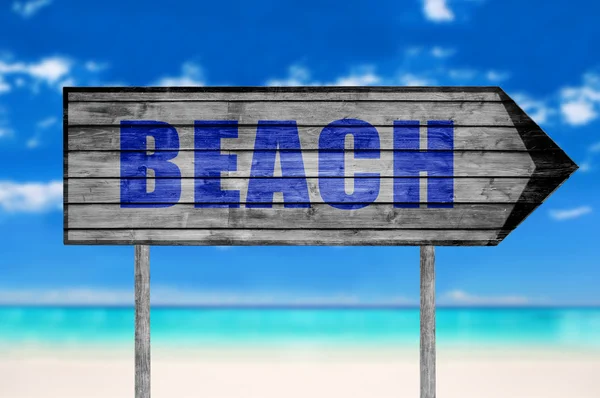 Cartel de madera de playa con una playa en el fondo — Foto de Stock