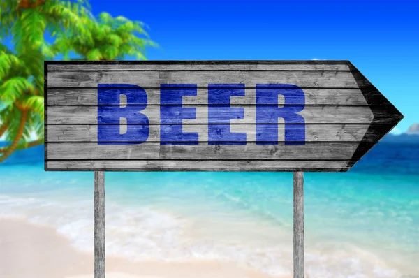 Деревянная табличка с пивом на фоне пляжа — стоковое фото