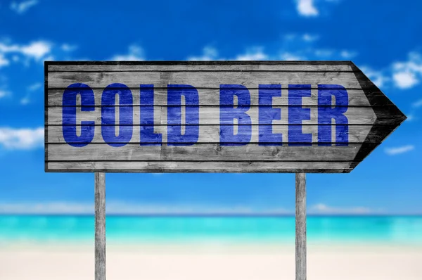 Kall öl träskylt med på stranden bakgrund — Stockfoto