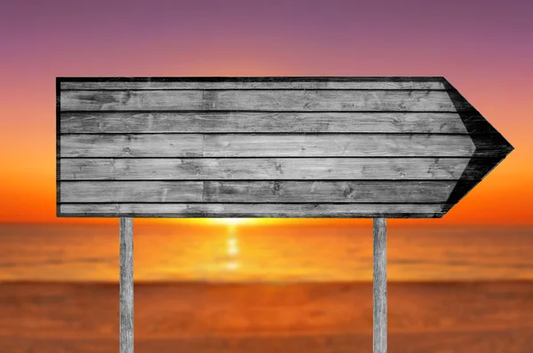 Empty wooden sign with a beach on background