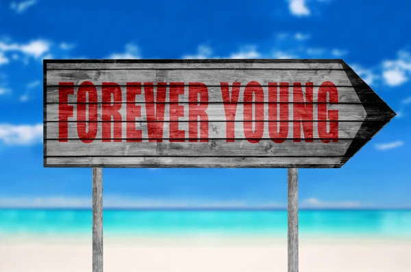 Señal roja para siempre joven con fondo de playa —  Fotos de Stock