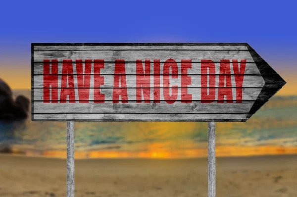 Red Have a Nice Day wooden sign with on a beach background