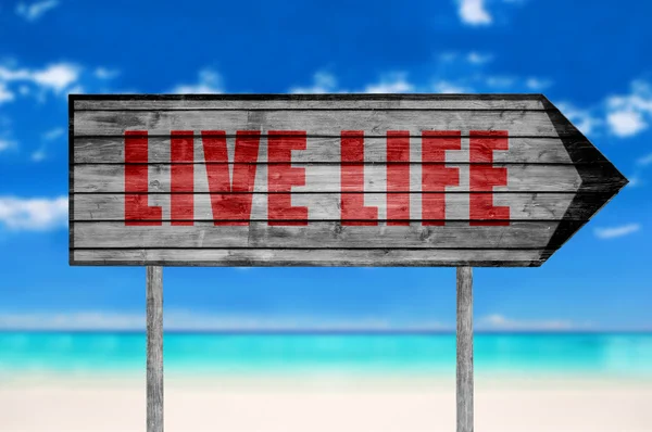 Cartel de madera de Red Live Life con una playa en el fondo — Foto de Stock