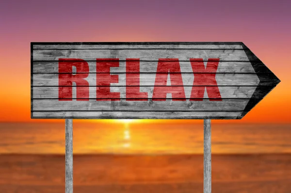 Rotes Relax-Holzschild mit einem Strand im Hintergrund — Stockfoto