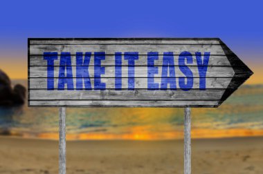 It Easy ahşap işareti ile bir plaj arka plan üzerinde almak