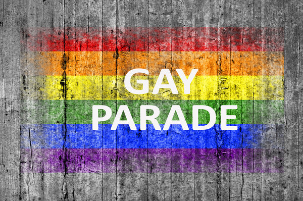 Парад геев и ЛГБТ-флаг на фоне серого бетона
