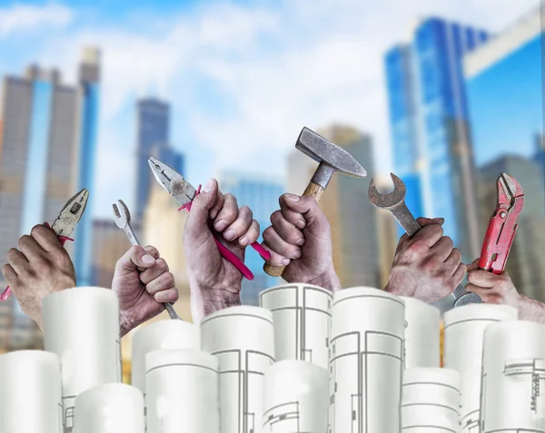 Several Hand holding tool with architect plans and city background