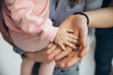 Üç Kafkasyalı avuçlarını üst üste istifliyor. Anne, baba ve kız el ele tutuşuyorlar. Destek ve sevgi göstergesi, birliktelik göreceli insanlar konsepti.