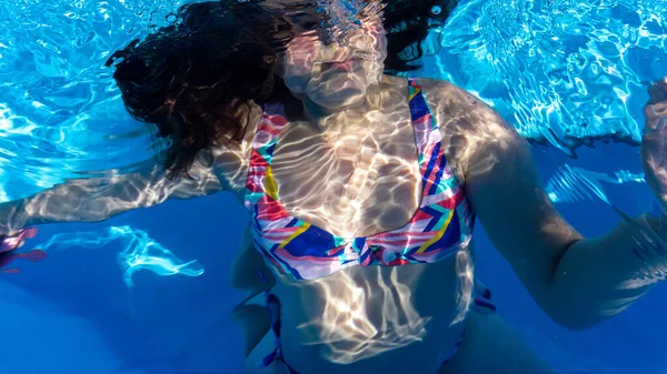 少女はプールの青い水に浸かり — ストック写真