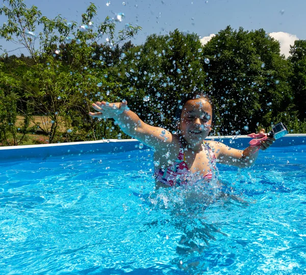 Girl in a pool splashing water very funny with her games