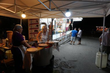 Galiçya 'daki festivallerde yemek yemek için ahtapot satan kadınlar müşteri bekliyor.