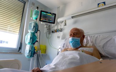 Hastanedeki yaşlı adam hayati belirtilerini izleyen makinelere bağlı.