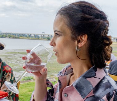 Kadın cam bardaktan su içerek susuzluğunu giderecek.