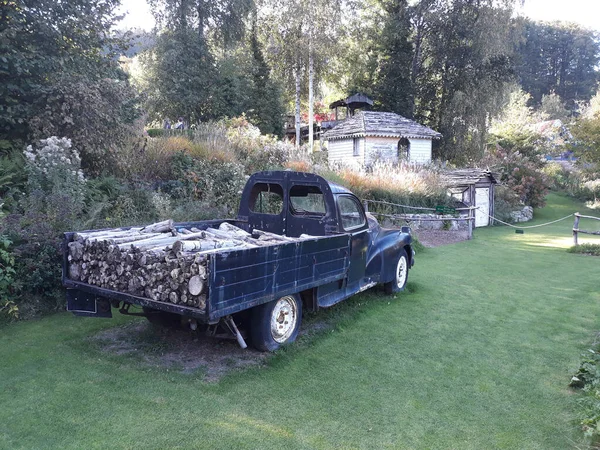 芝生のある庭に薪を積んだ古いピックアップトラックは非常によく刈られた ロイヤリティフリーのストック写真