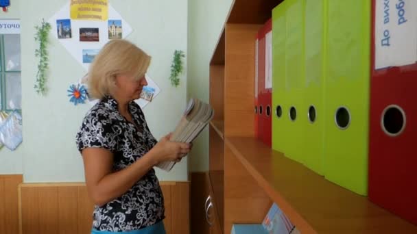 Leraar vouwen de schoolboeken — Stockvideo